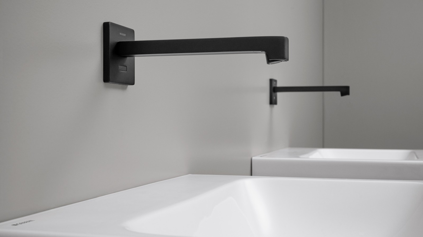 Geberit Brenta touchless washbasin tap. Wall-mounted tap in a square design in black matt