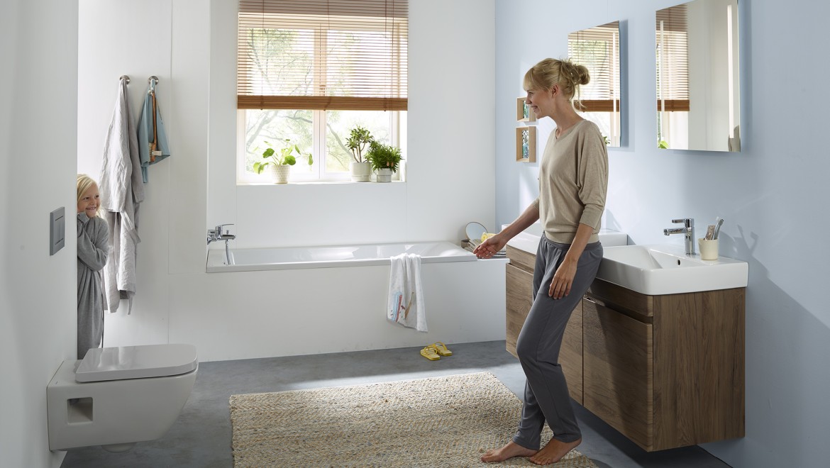 Woman and child stand in the family bathroom of the Geberit Renova series (© Geberit)