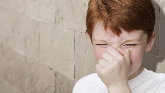 Boy holds his nose