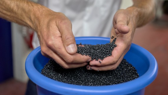 Hands holding black plastic pellets (© Ben Huggler) Hands holding black plastic pellets (© Ben Huggler)