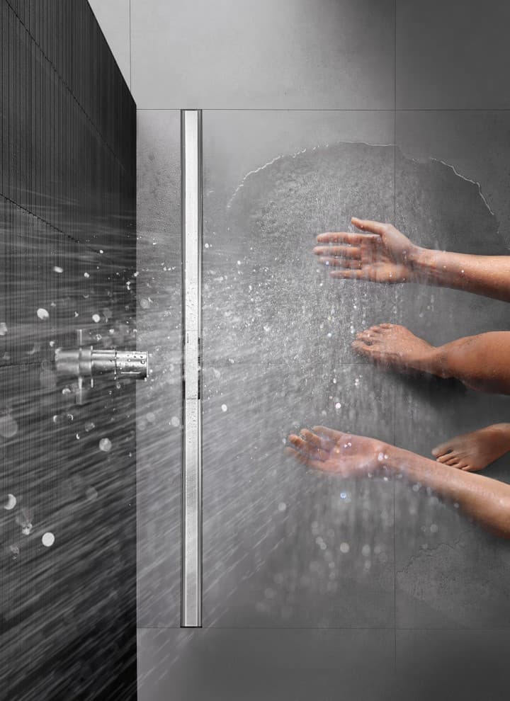 Person showering in a floor-even shower with CleanLine Person showering in a floor-even shower with CleanLine